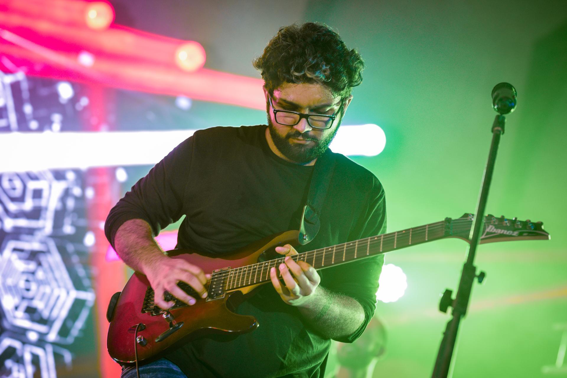 Saagar Takhi with a red electric guitar playing a song